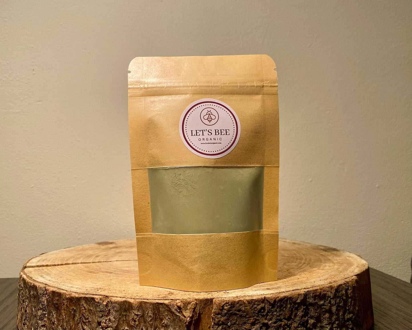 50g bag of pure organic matcha powder on top of a wood log with the sticker of Let's Bee Organic.